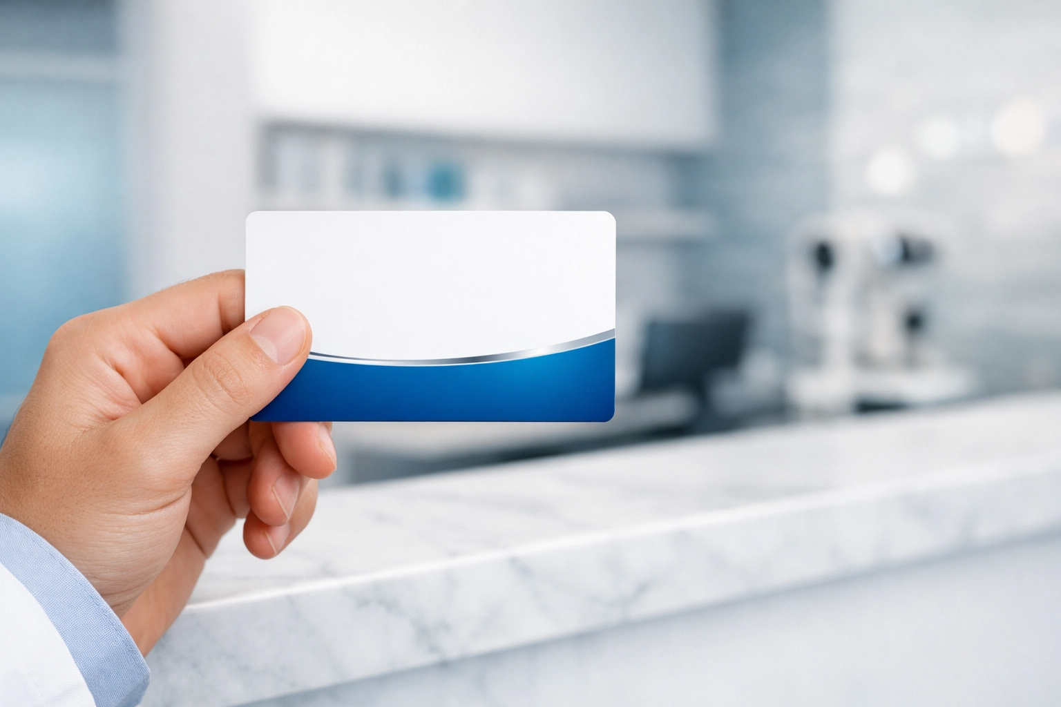 Front desk staff holding an insurance card for optometry eligibility verification and billing.