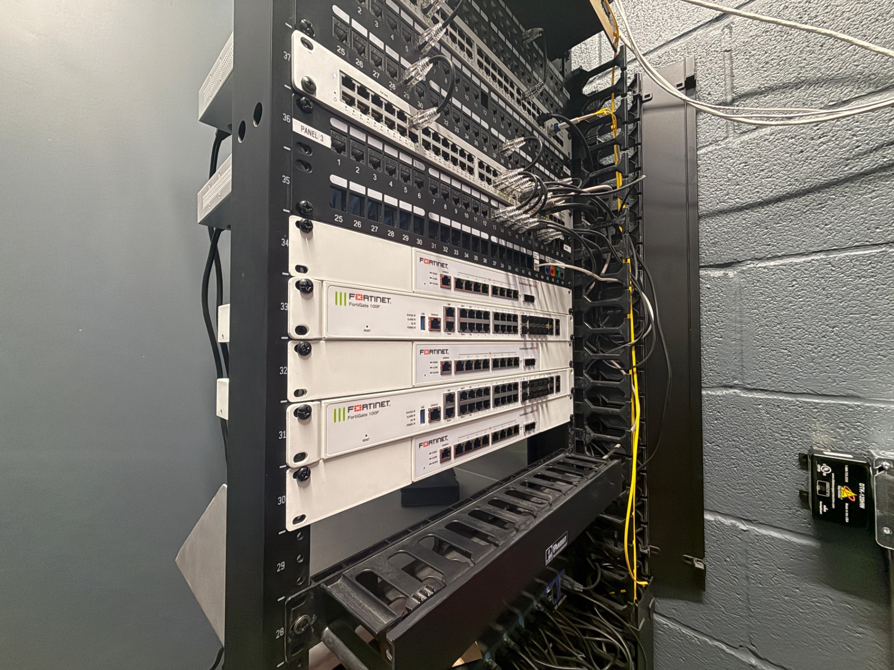 Network rack featuring Fortinet FortiGate 100F firewalls