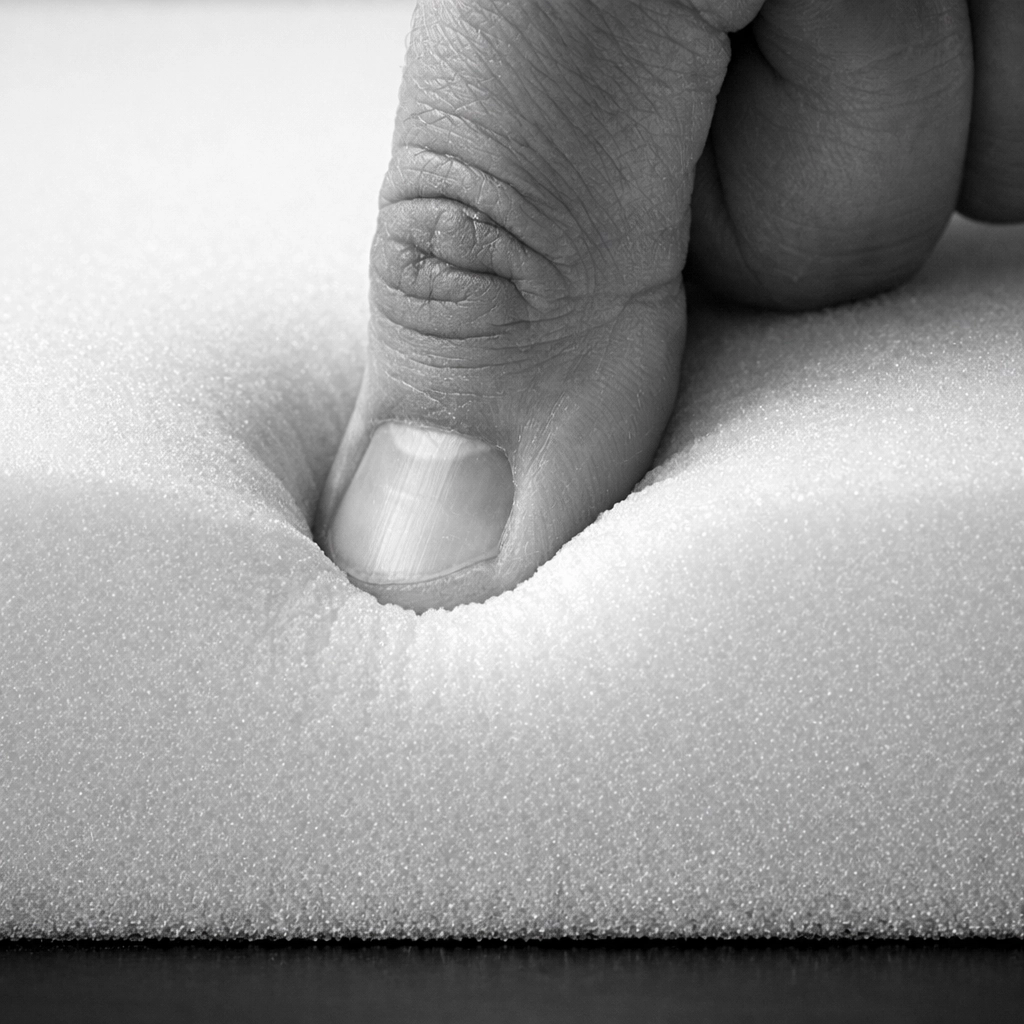 Hand testing the density and support of premium custom foam at Stuff It Upholstery in Chattanooga.