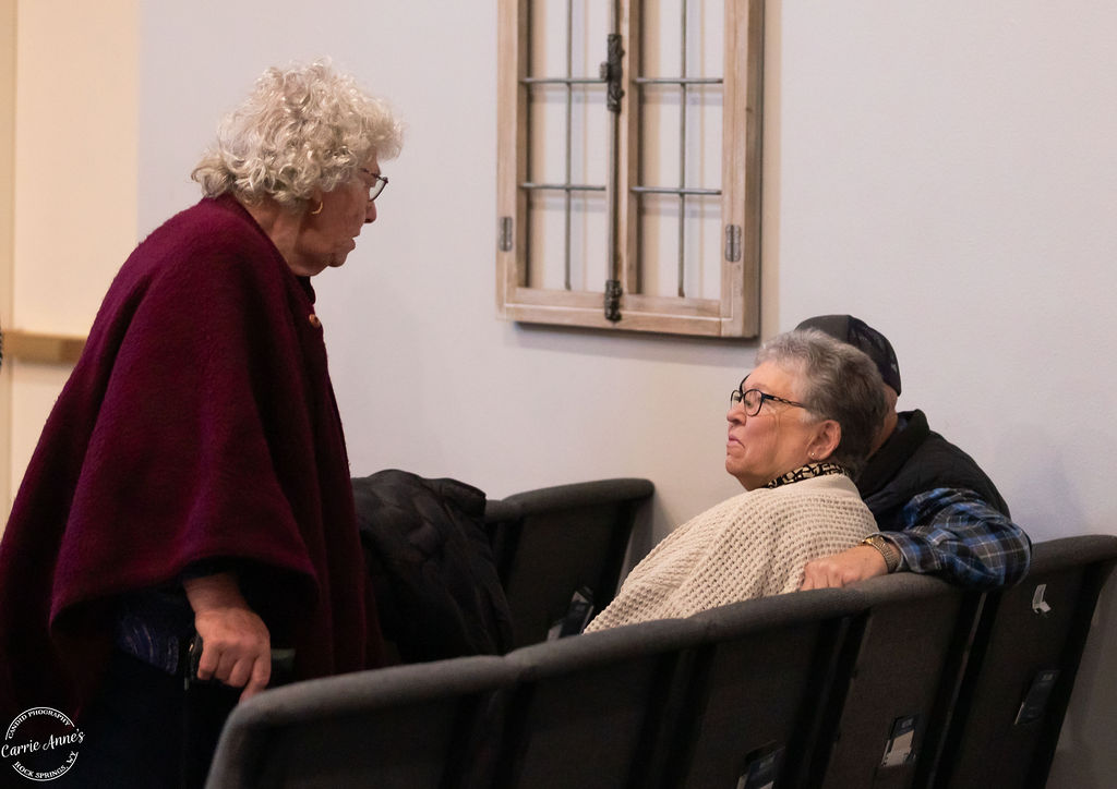 Three older adults connect before Sunday worship