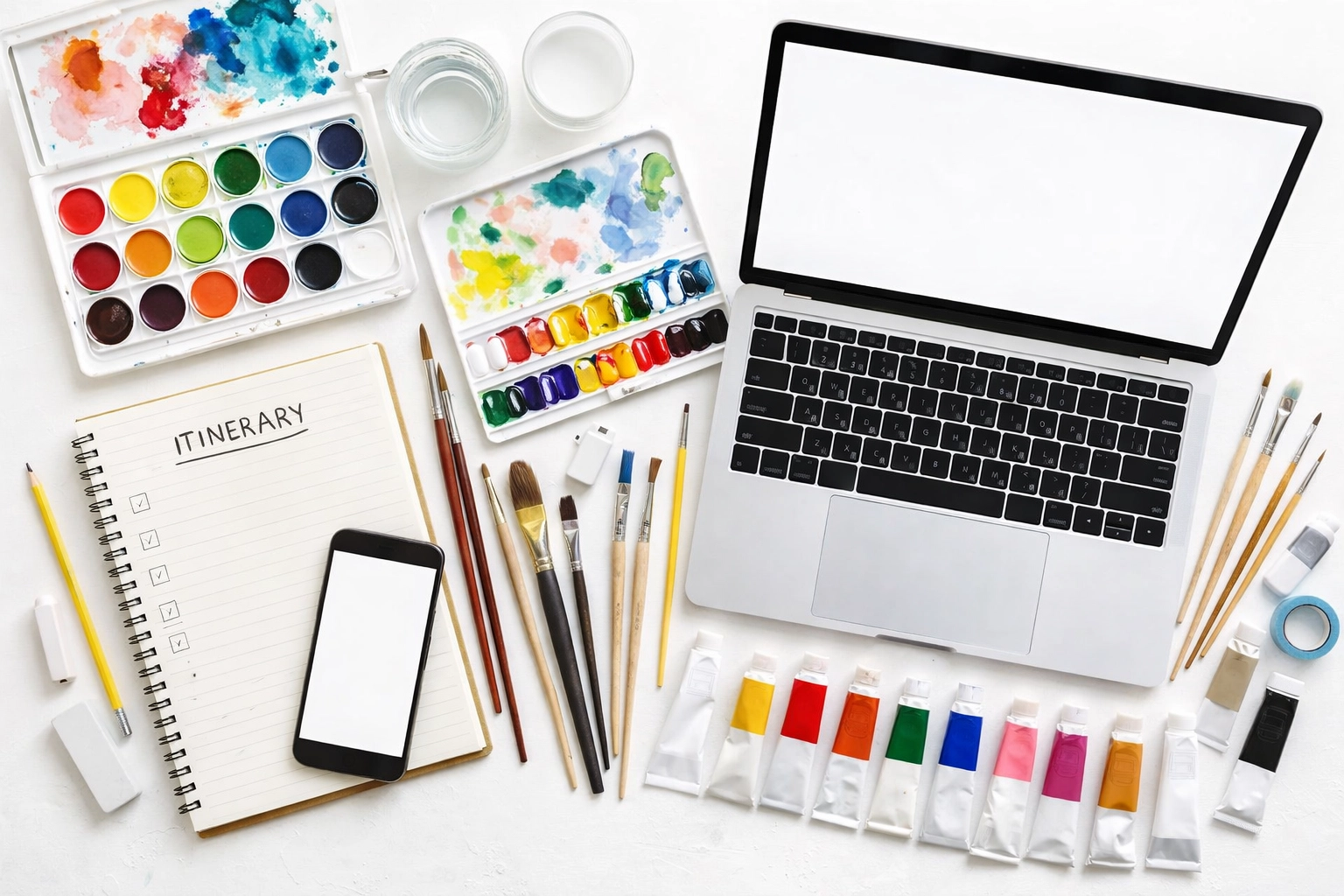 Organized art workstation with watercolor and acrylic palettes, brushes, and planning notebook