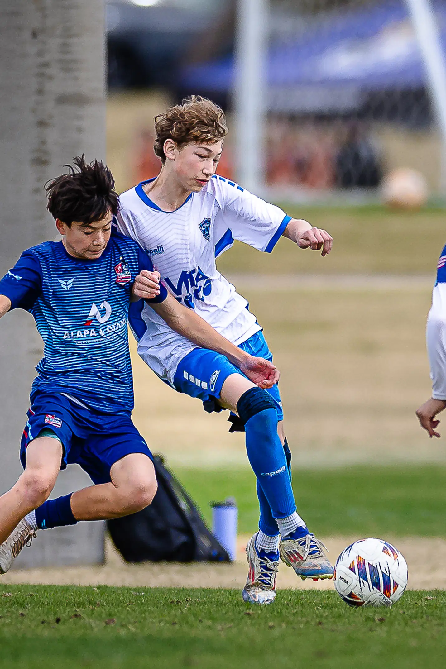 Two youth soccer players compete for possession, demonstrating the split-second determination that professional photography immortalizes.
