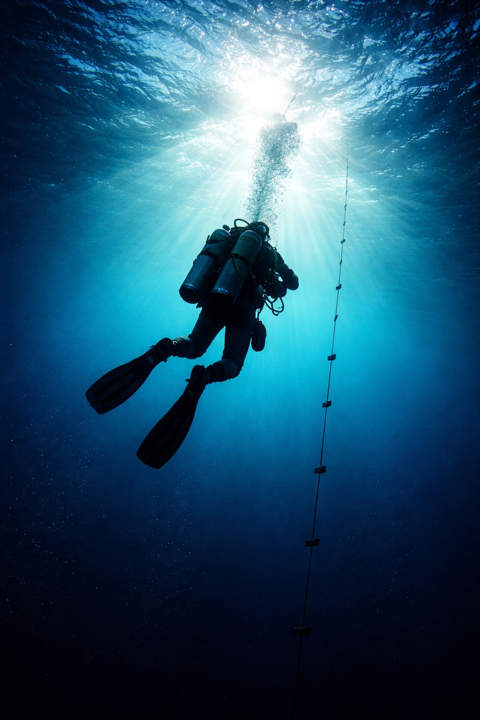 Technischer Taucher beim Abstieg in tiefe, blaue Gewässer, symbolisiert Deep Diving und Abenteuer im Technical Diving