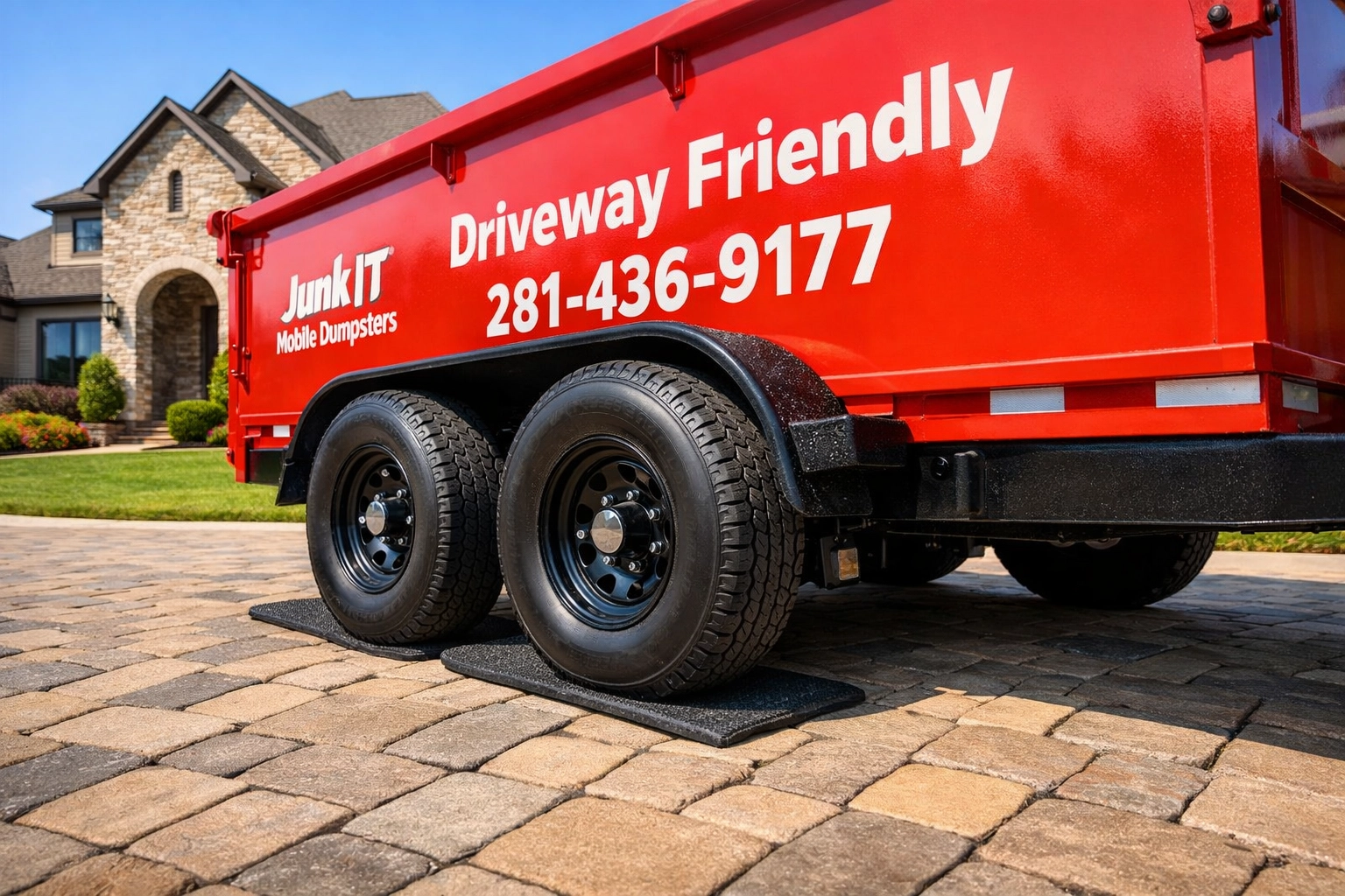 Junk It Mobile Dumpsters trailer with driveway-safe tires on a luxury stone paver driveway in Pearland.