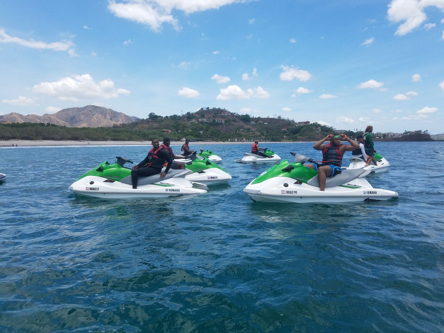 Group adventure participants enjoying a Signature Experience on jet skis in crystal blue coastal waters.