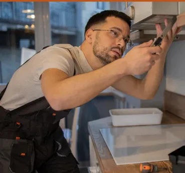 Expert handyman installing cabinets with precision