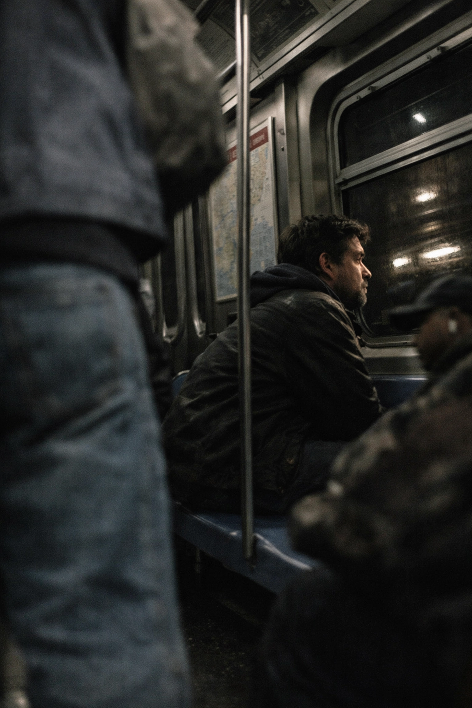 Candid street photography of a passenger on a NYC subway using a shooting from the hip technique.