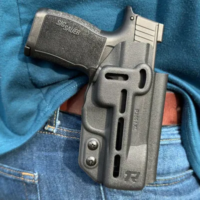 OWB KYDEX holster securely holding a Sig Sauer pistol on a brown belt