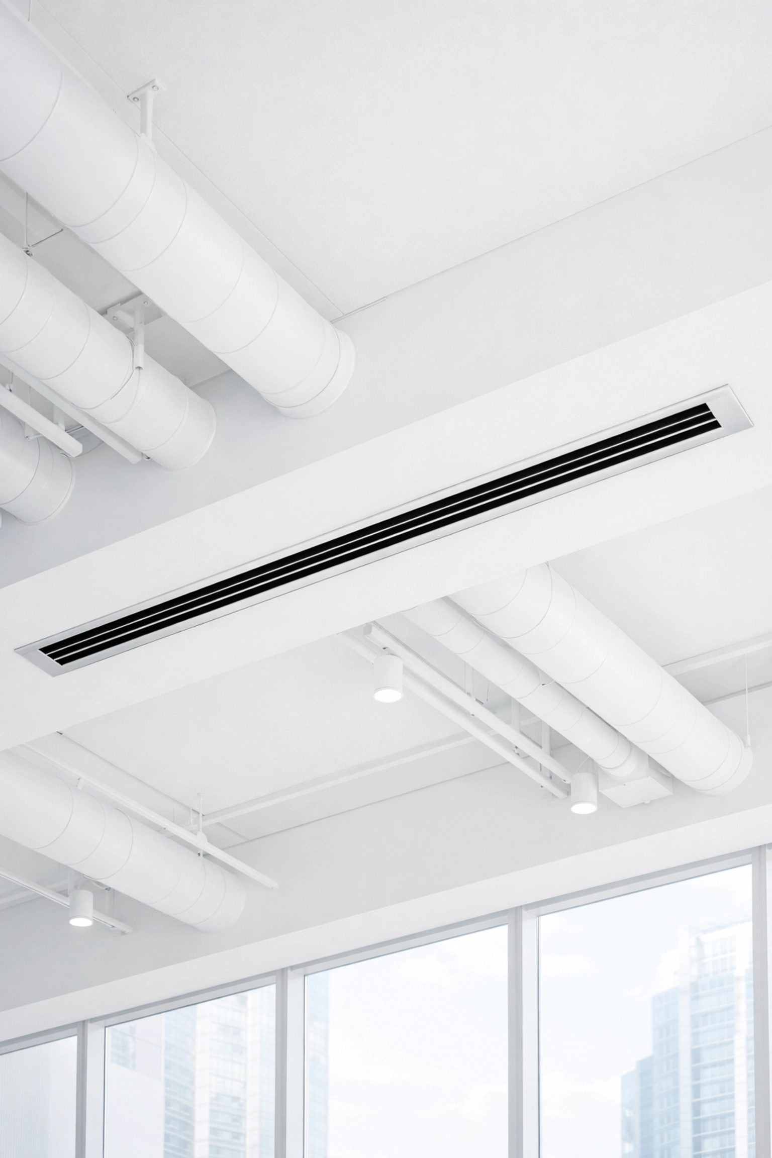 Clean white HVAC vents and air ducts in a modern office improving indoor air quality.