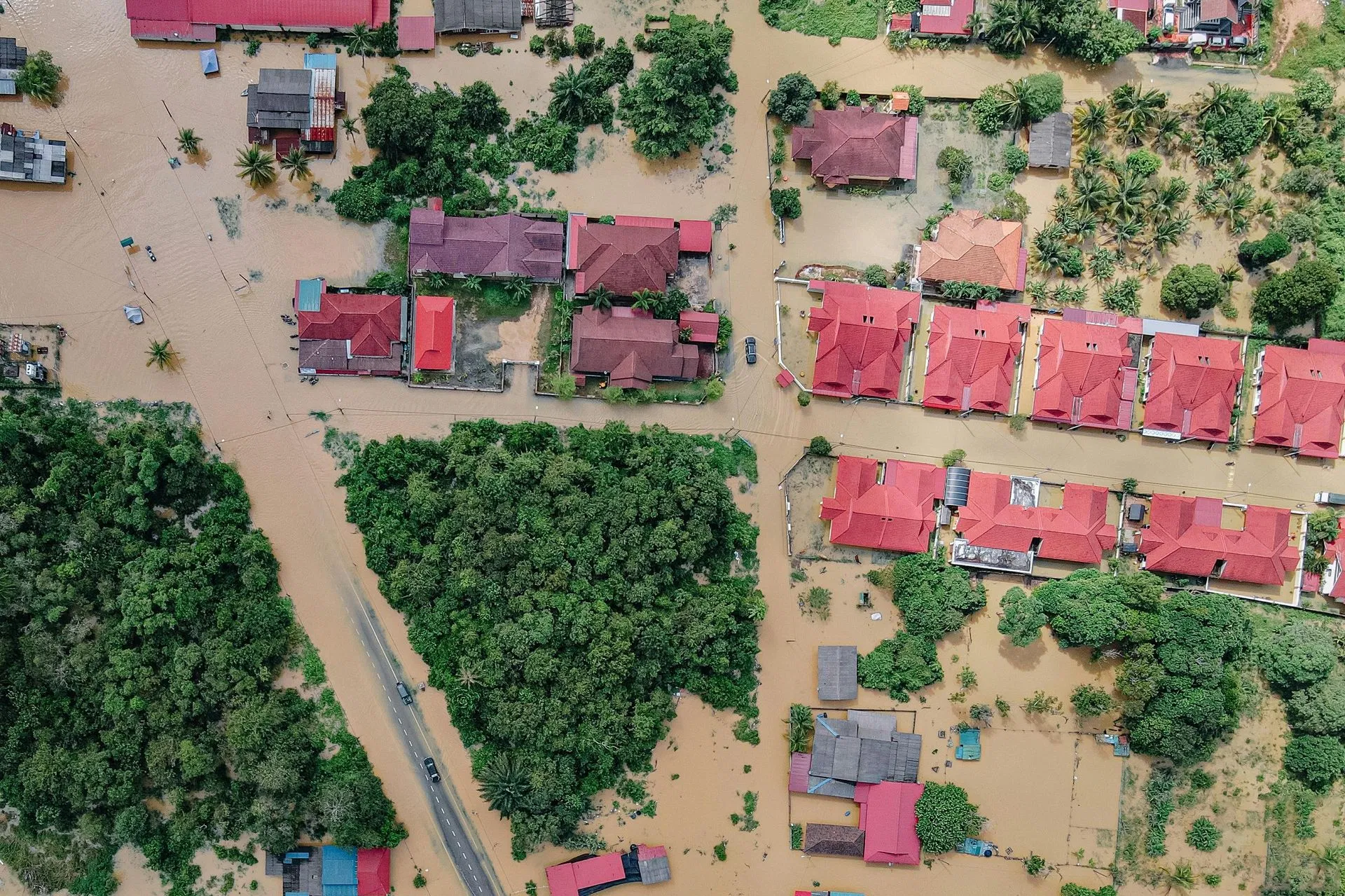 Aerial view of a neighborhood experiencing severe street and property flooding.