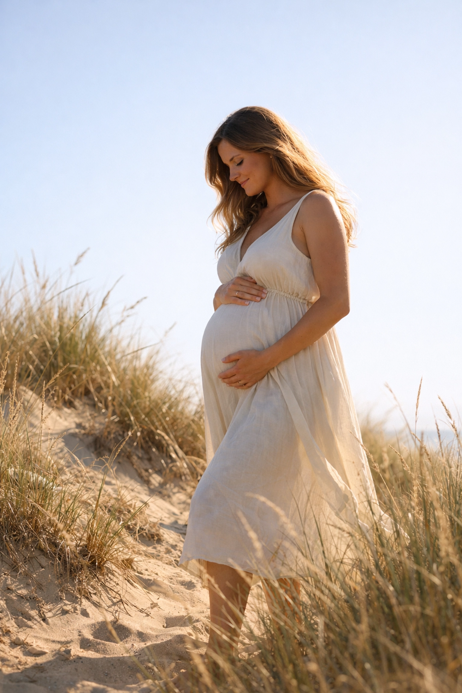 Maternity photoshoot at Curl Curl Beach sand dunes with an expectant mother in natural light.