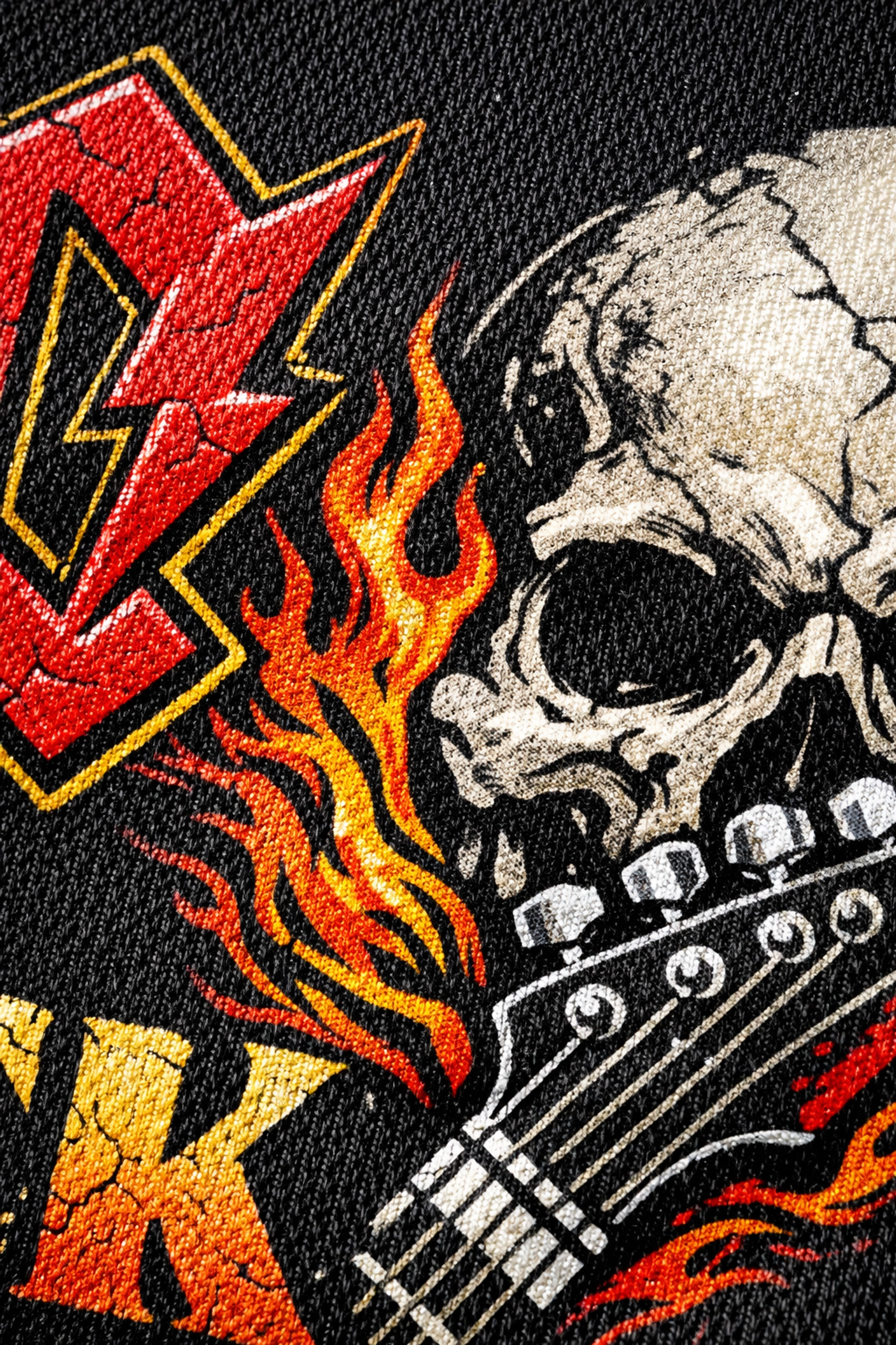 Close-up detail of high-quality screen printing on an official black cotton rock band t-shirt.