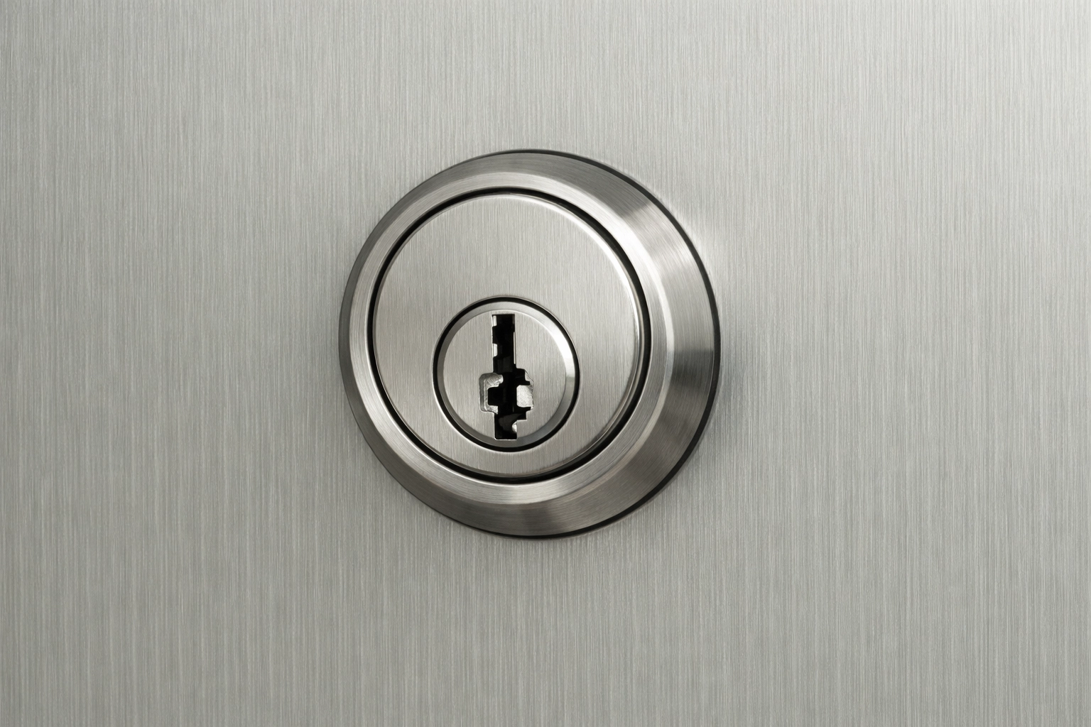 High-security lock cylinder and keyway on a brushed metal door, minimal and uncluttered.