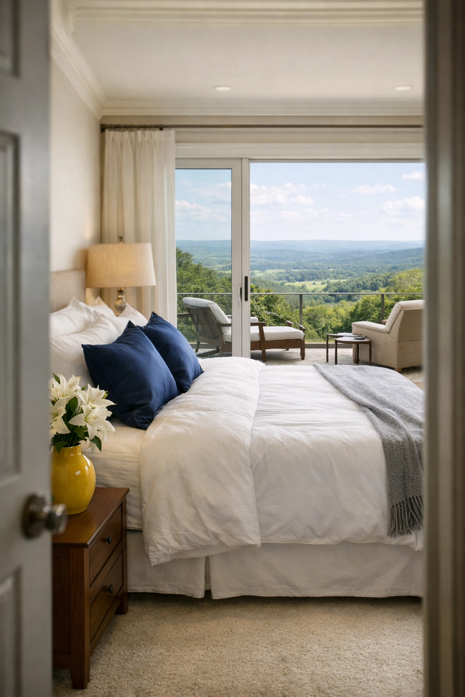 Spotless luxury master suite in Groton with white linens and a view of the Massachusetts countryside.