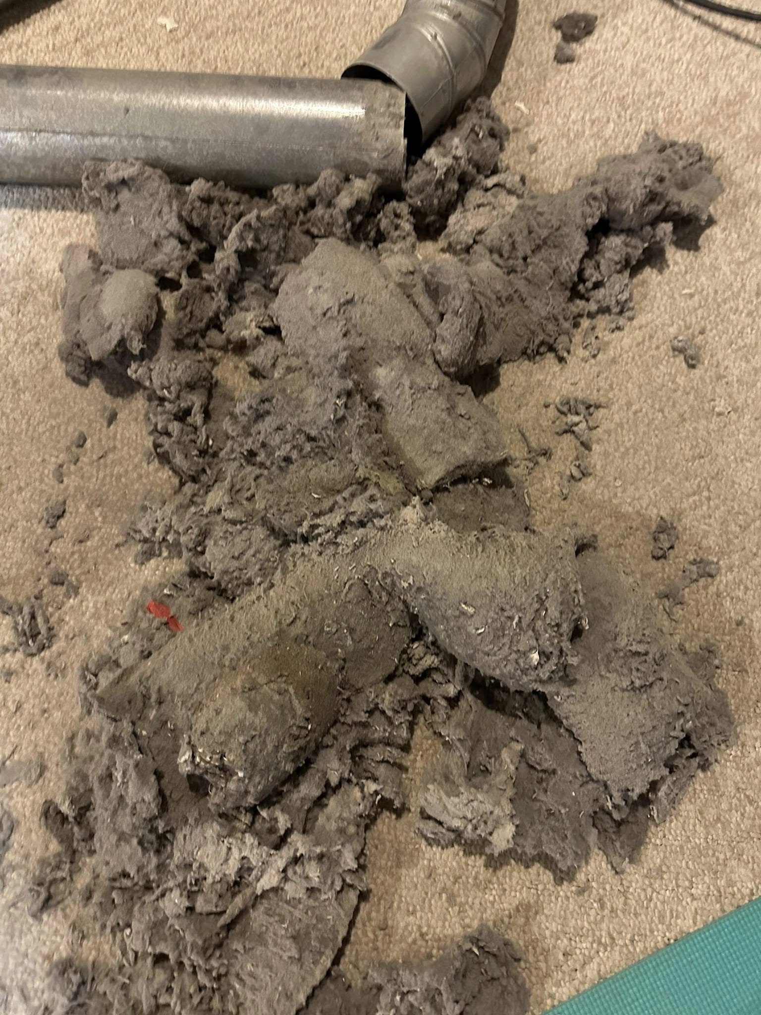 Heavy buildup of lint removed from inside a dryer vent duct, showing how severe clogs accumulate over time.