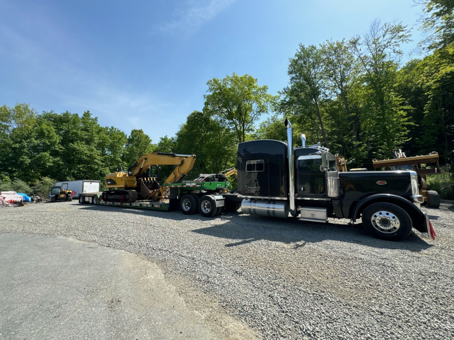 Heavy-duty truck and lowboy trailer with excavator