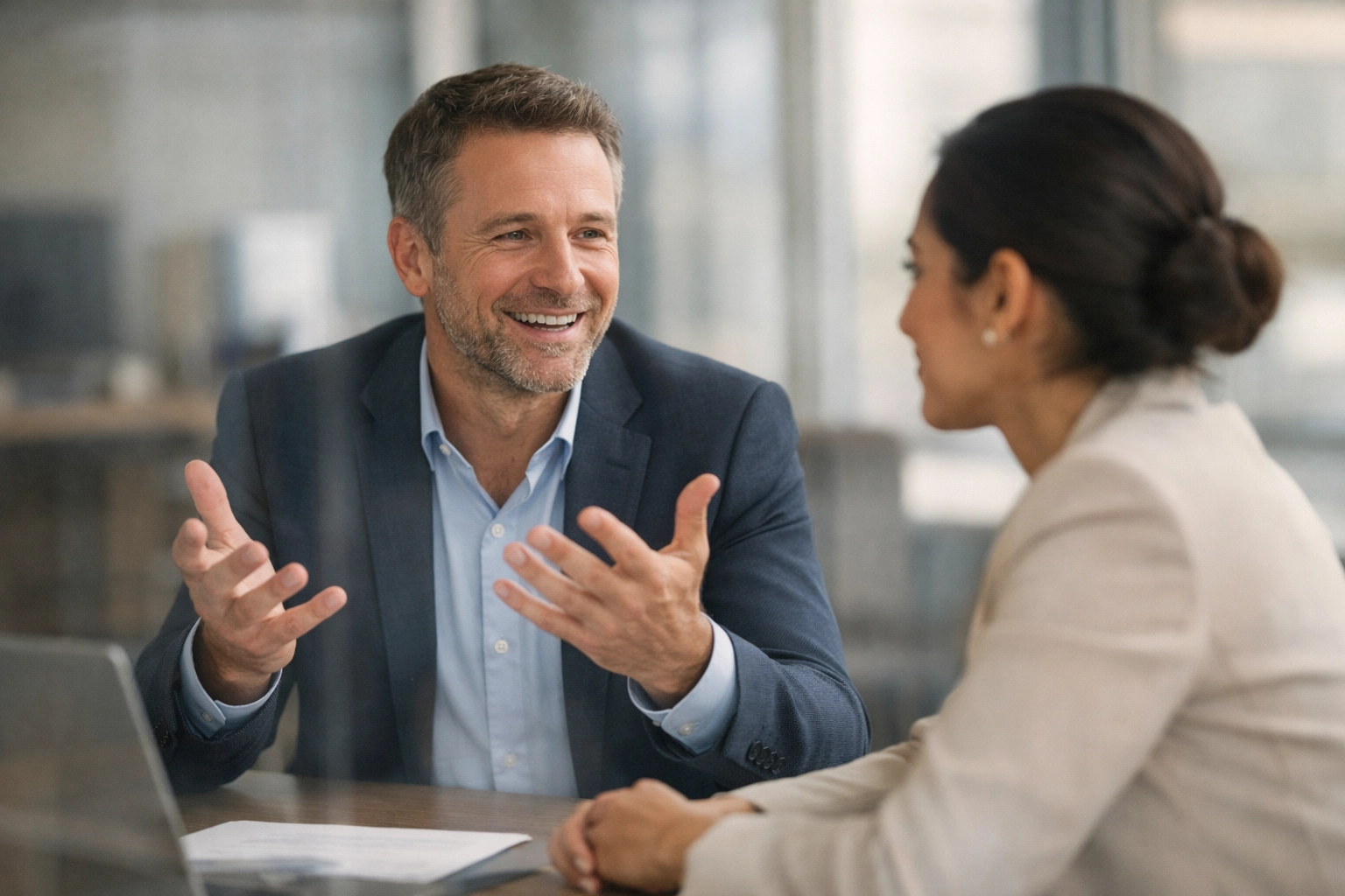 Leader showing vulnerability in authentic conversation with team member in modern office