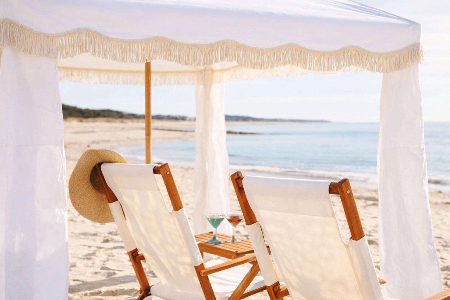 Luxury New Smyrna Beach setup with a premium white canvas fringe cabana (Business & Pleasure style) and reclining canvas chairs—VIP and effortless