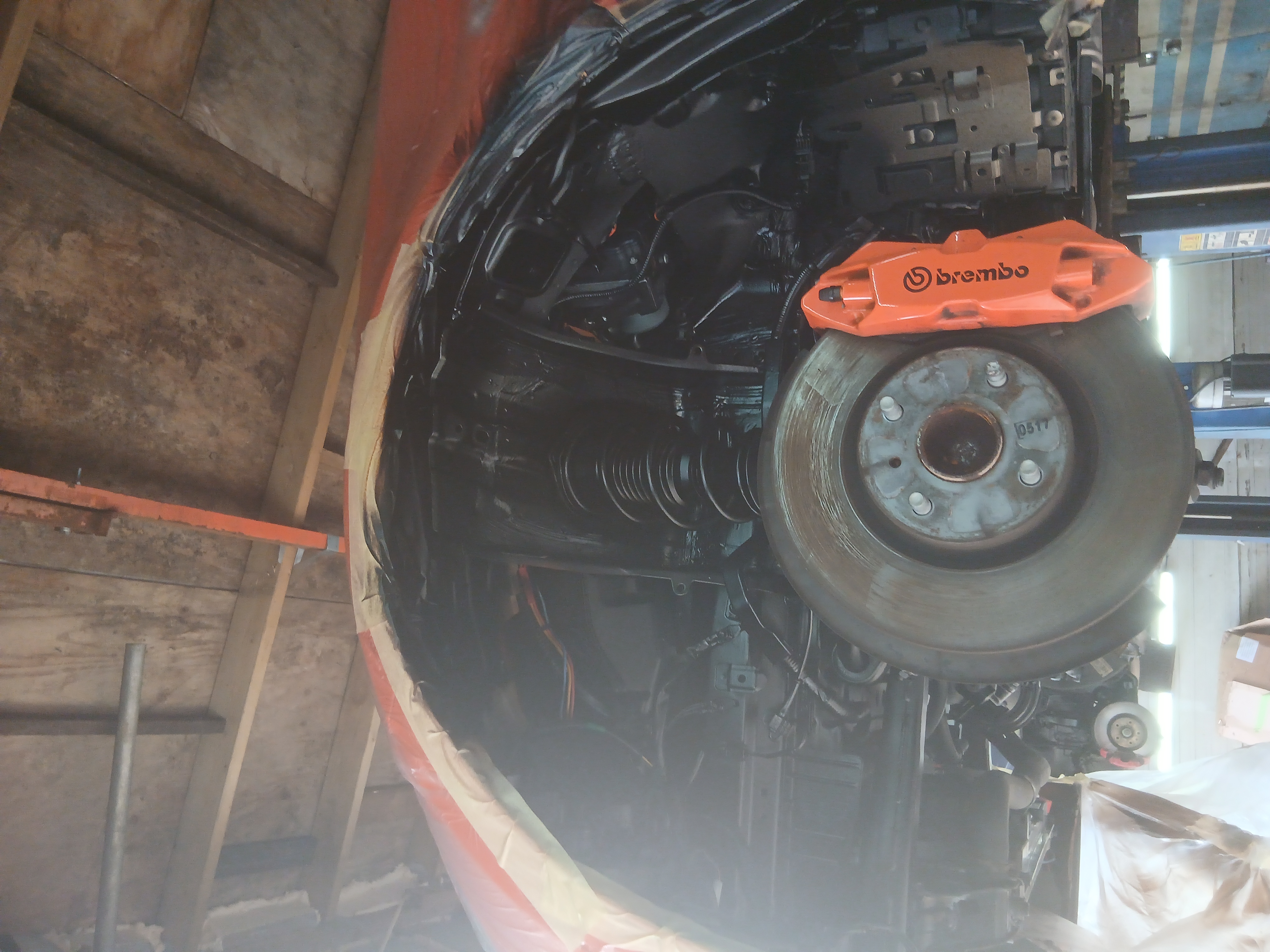 The vehicle’s front suspension and brake system freshly coated with rustproofing treatment