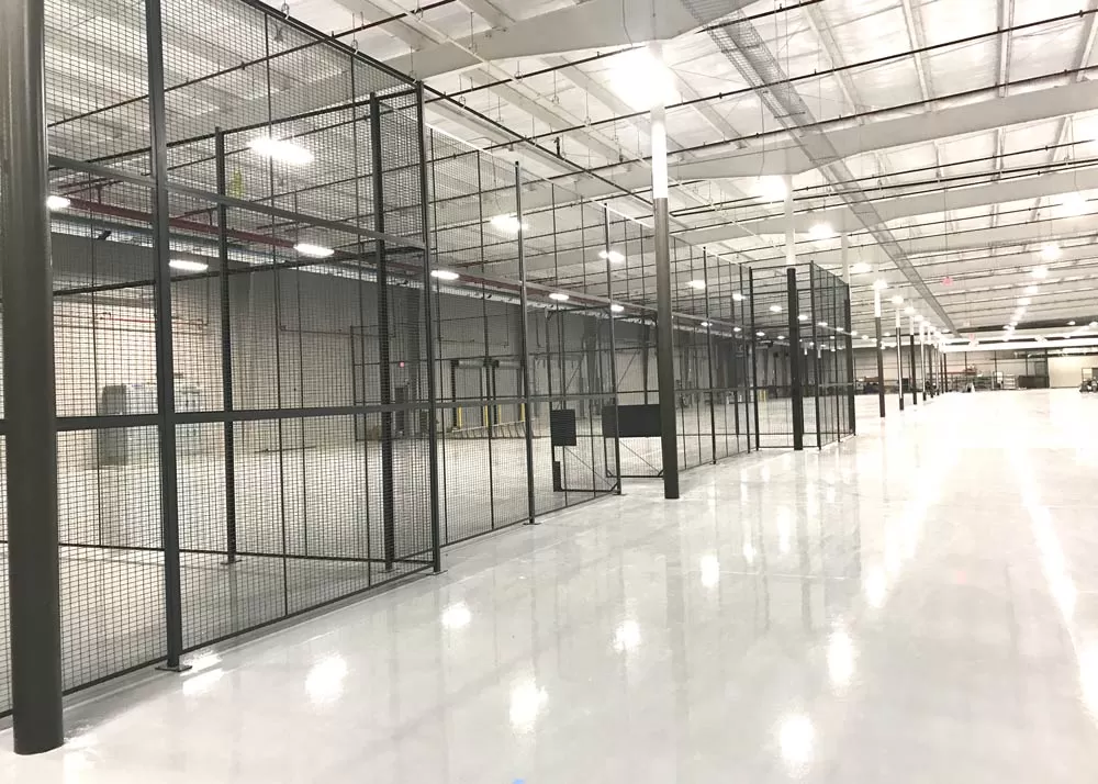 Contrast between slow drywall construction permits and a fast modular wire mesh warehouse security cage.
