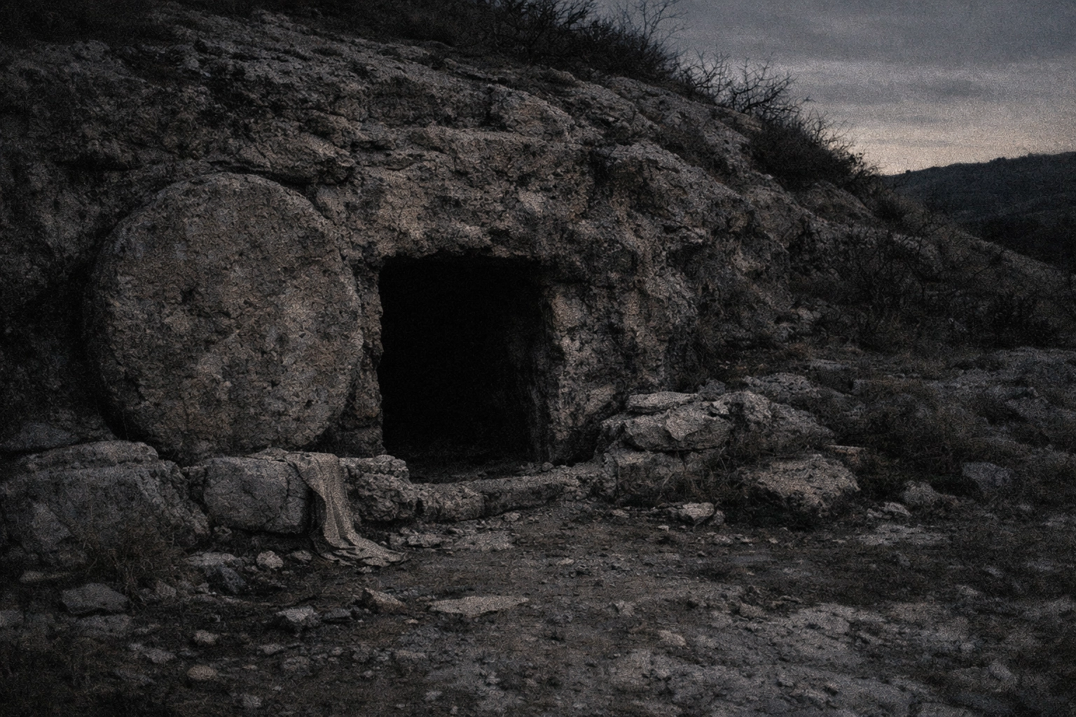 A dark, empty tomb entrance in rough stone—quiet, heavy, and unresolved.