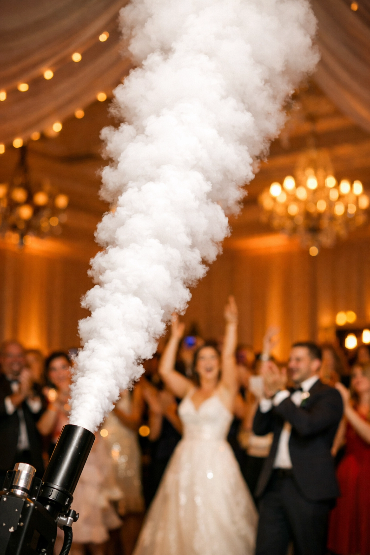 Dramatic CO2 cannon blast creating a white fog cloud for a high-energy wedding reception entrance.