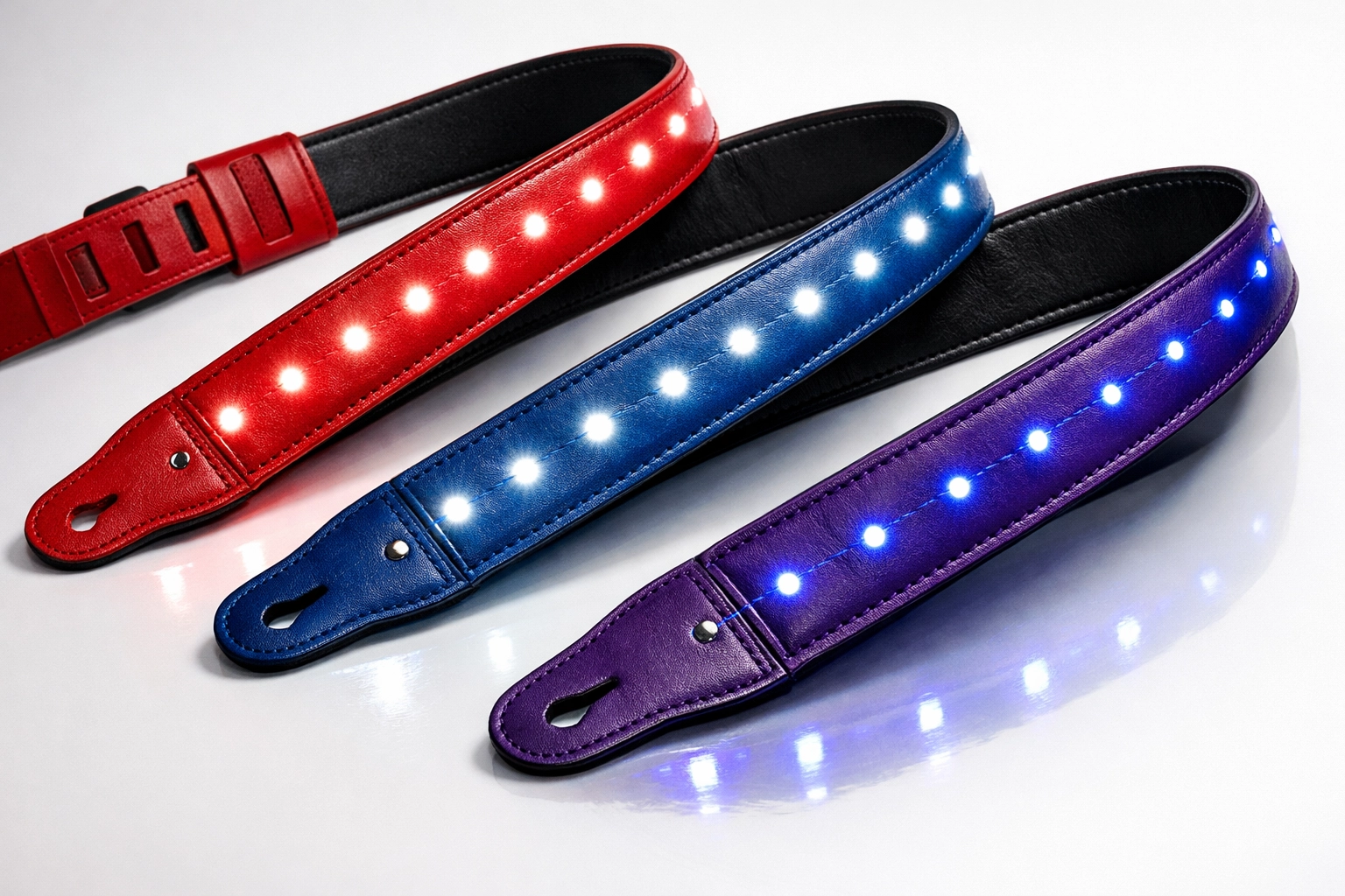 Red, blue, and purple leather guitar straps with LED lights displayed together