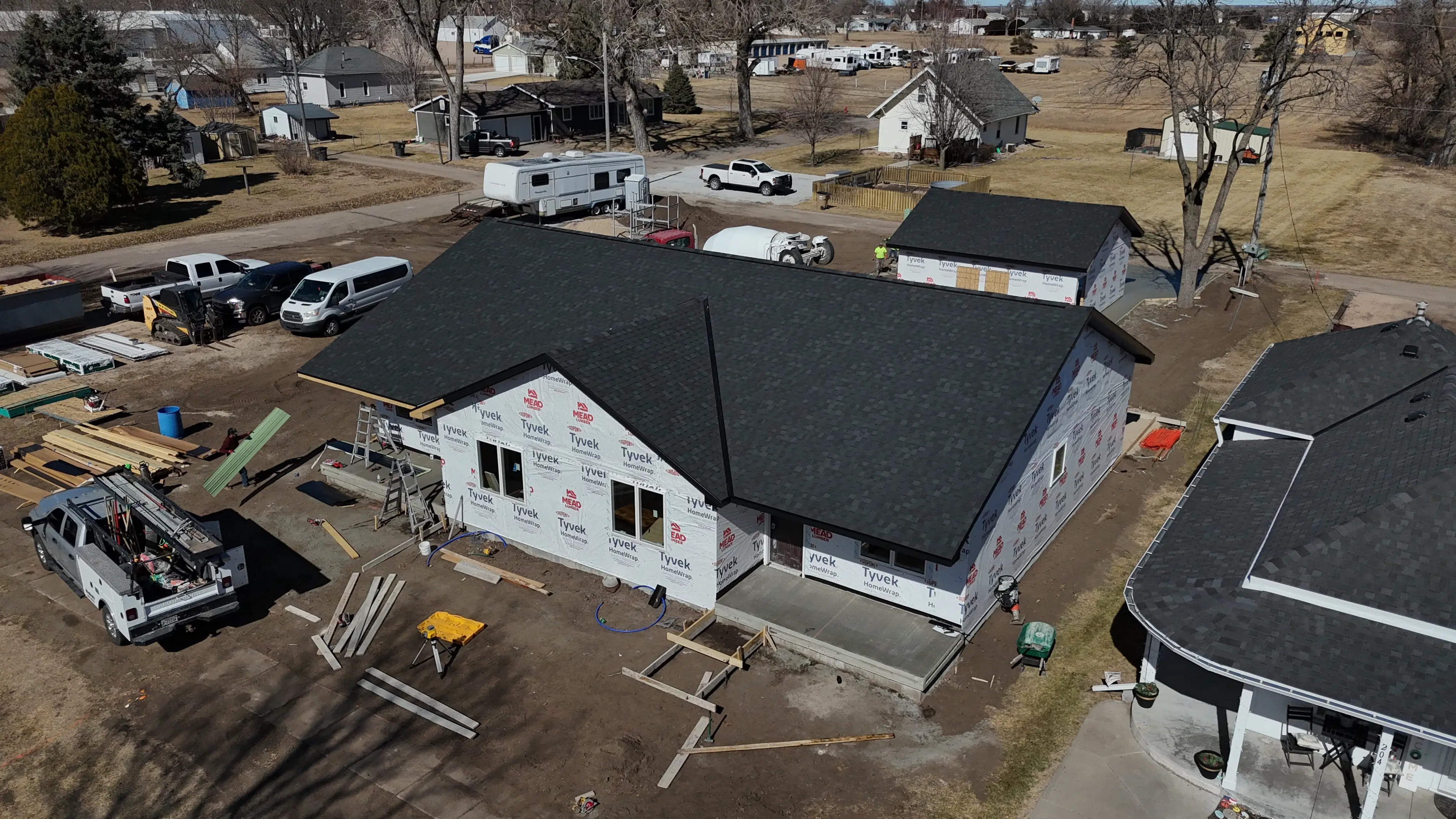 Aerial view of a residential construction site featuring a freshly poured concrete porch