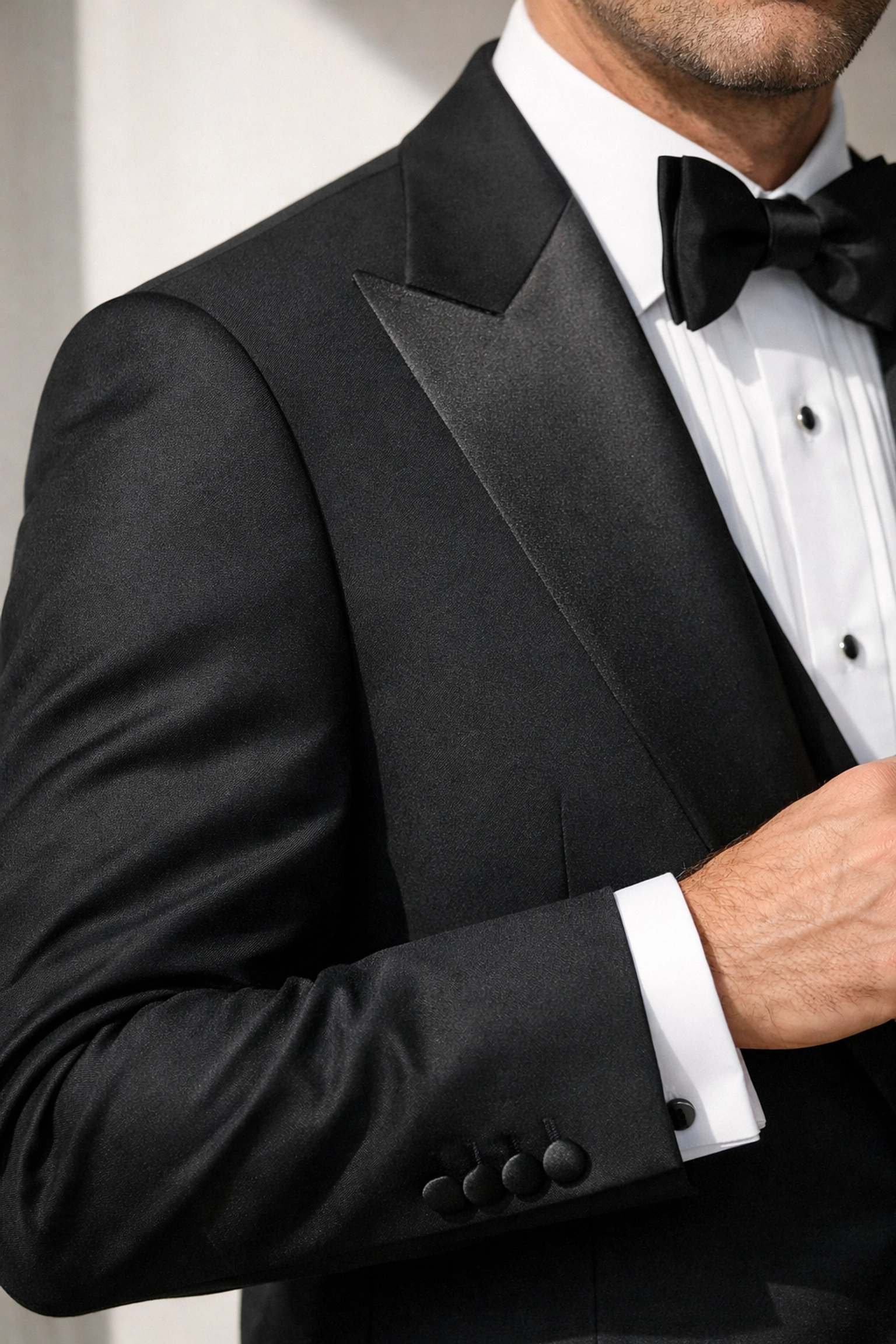 Close-up of properly fitted black tuxedo jacket showing correct sleeve and shoulder fit