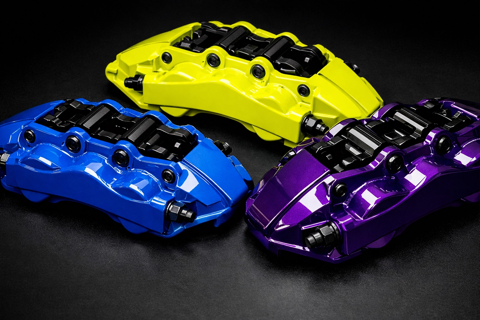 Custom powder coated brake calipers in blue, yellow, and purple colors