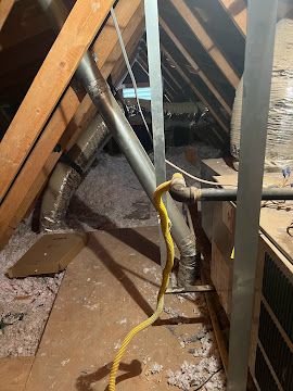 Attic with exposed ductwork and plumbing lines in an Arizona home.