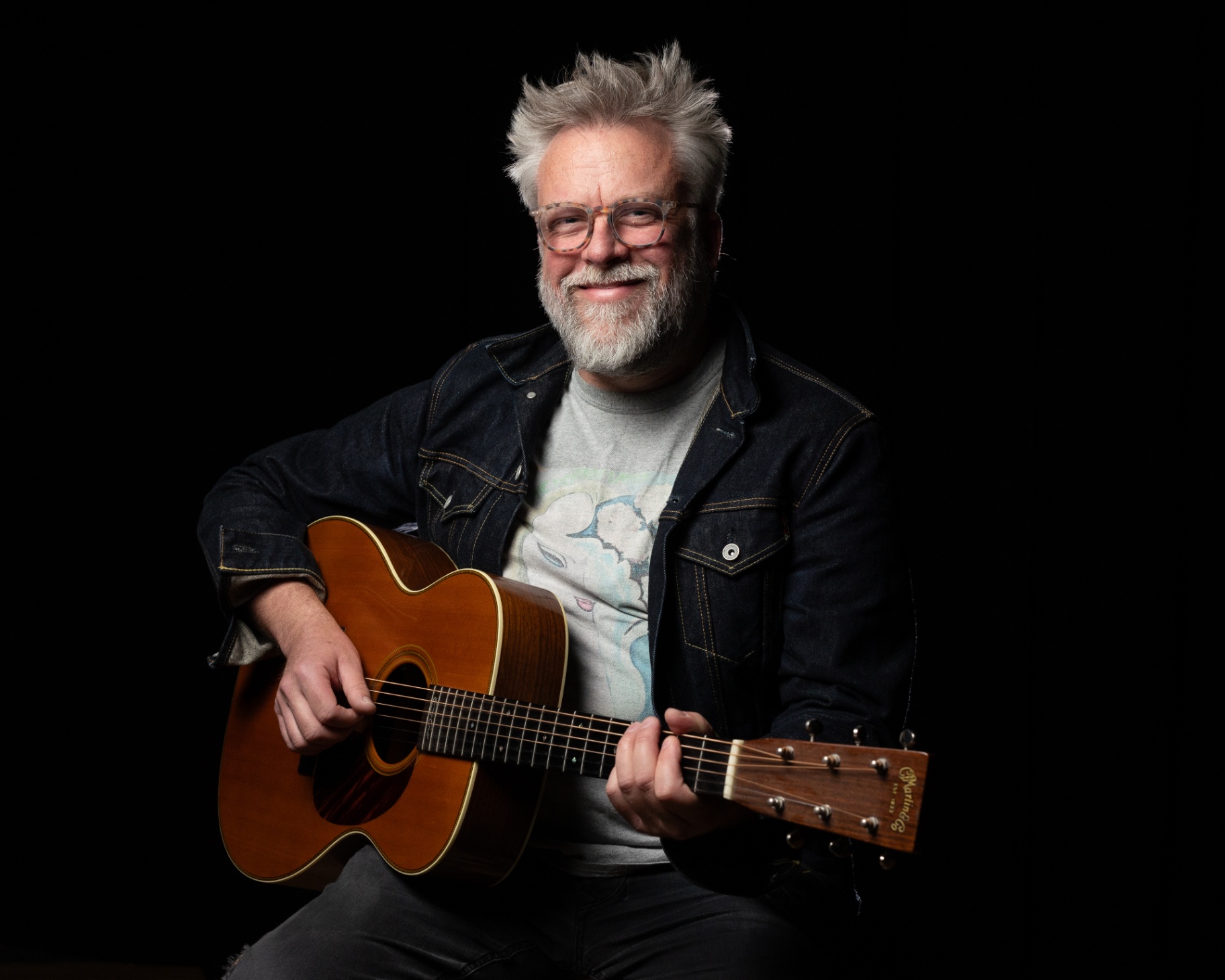 Band member of Damo and the Dominos with acoustic guitar