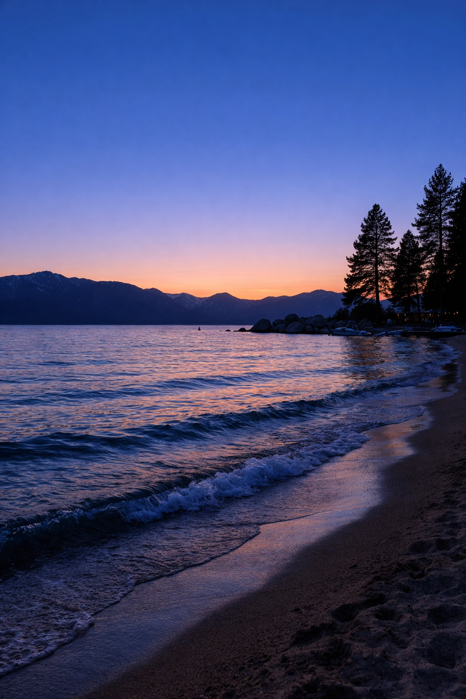 Colorful sunset sky over the Zephyr Cove shoreline and mountains in South Lake Tahoe.