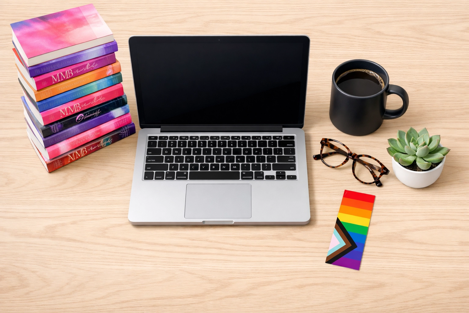 Modern book blogger workspace with a laptop and a stack of the best MM romance books of 2026.