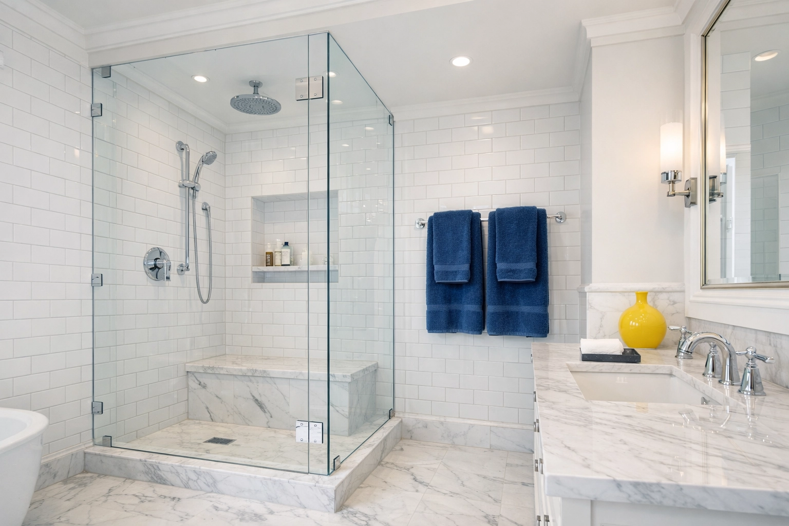 A sparkling clean walk-in shower with spotless glass doors and white subway tile in a luxury bathroom.
