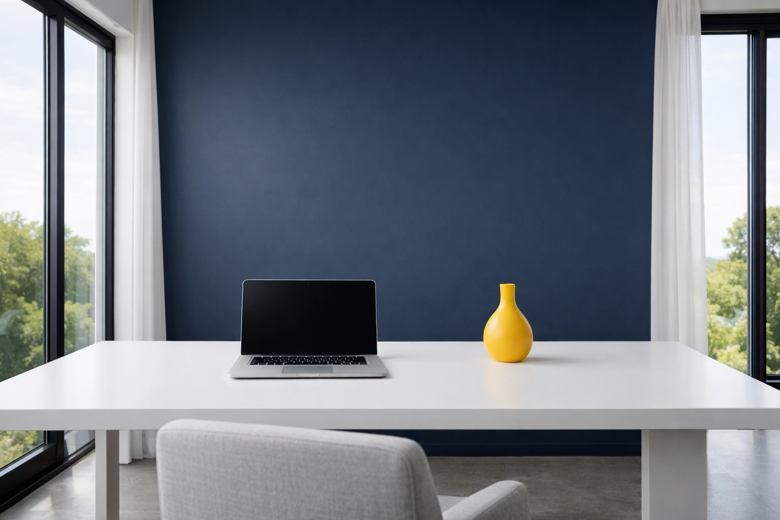 Minimalist home office with a white desk and navy wall, showing the mental clarity from weekly house cleaning.