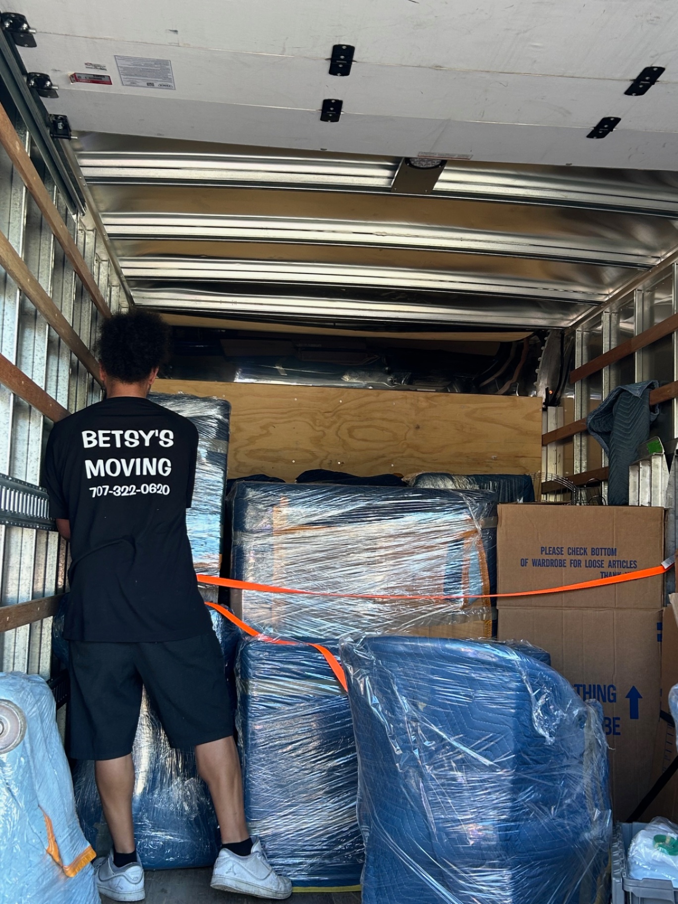 Betsy's Moving team member secures furniture in truck