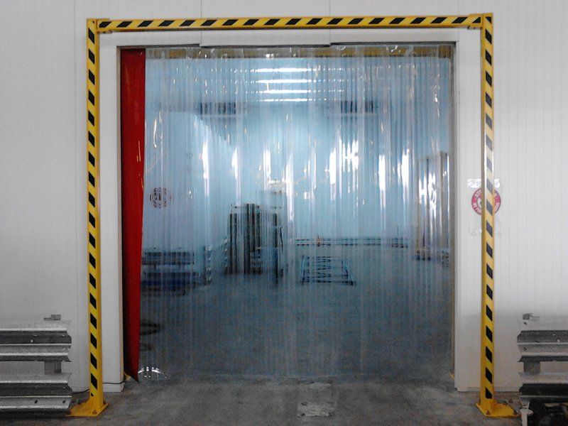 Heavy-duty clear PVC strip curtain installed in a wide loading bay doorway