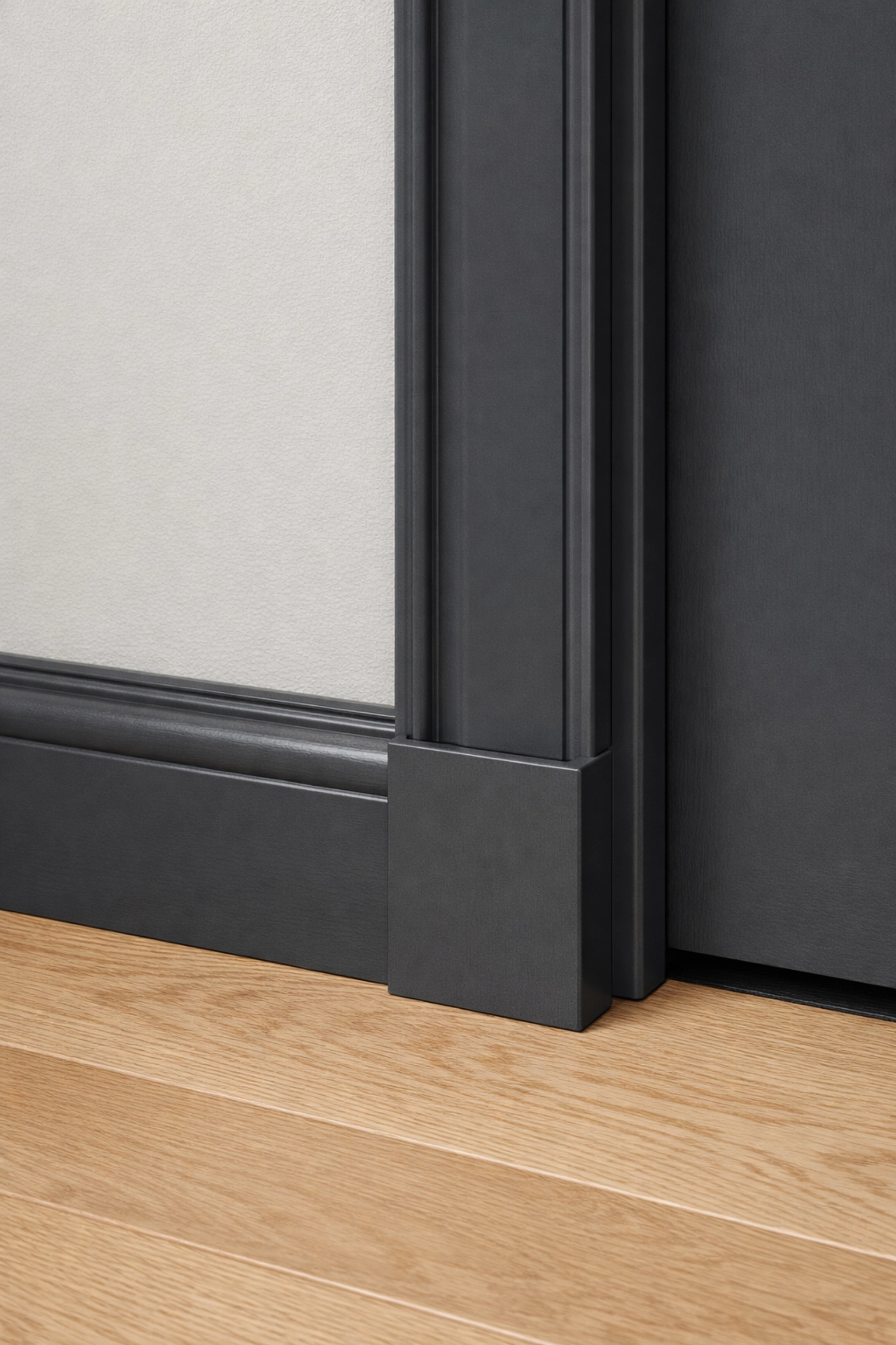 Dark charcoal grey skirting boards and door trim professionally painted in a Gloucestershire property.