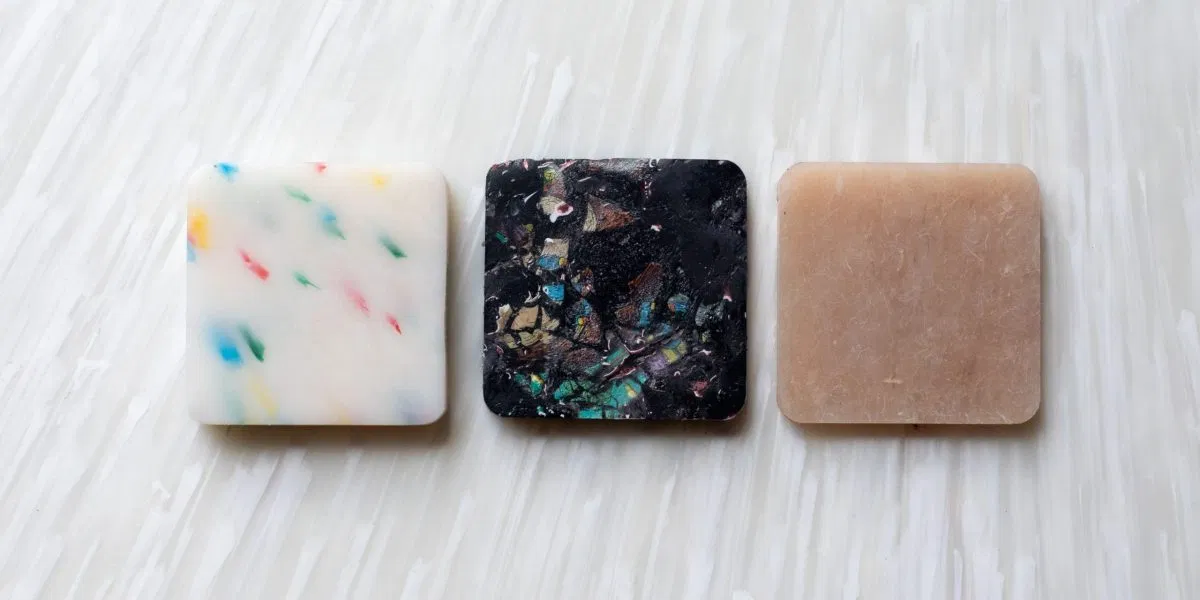 Three 100% recycled plastic panel samples are displayed in different colours