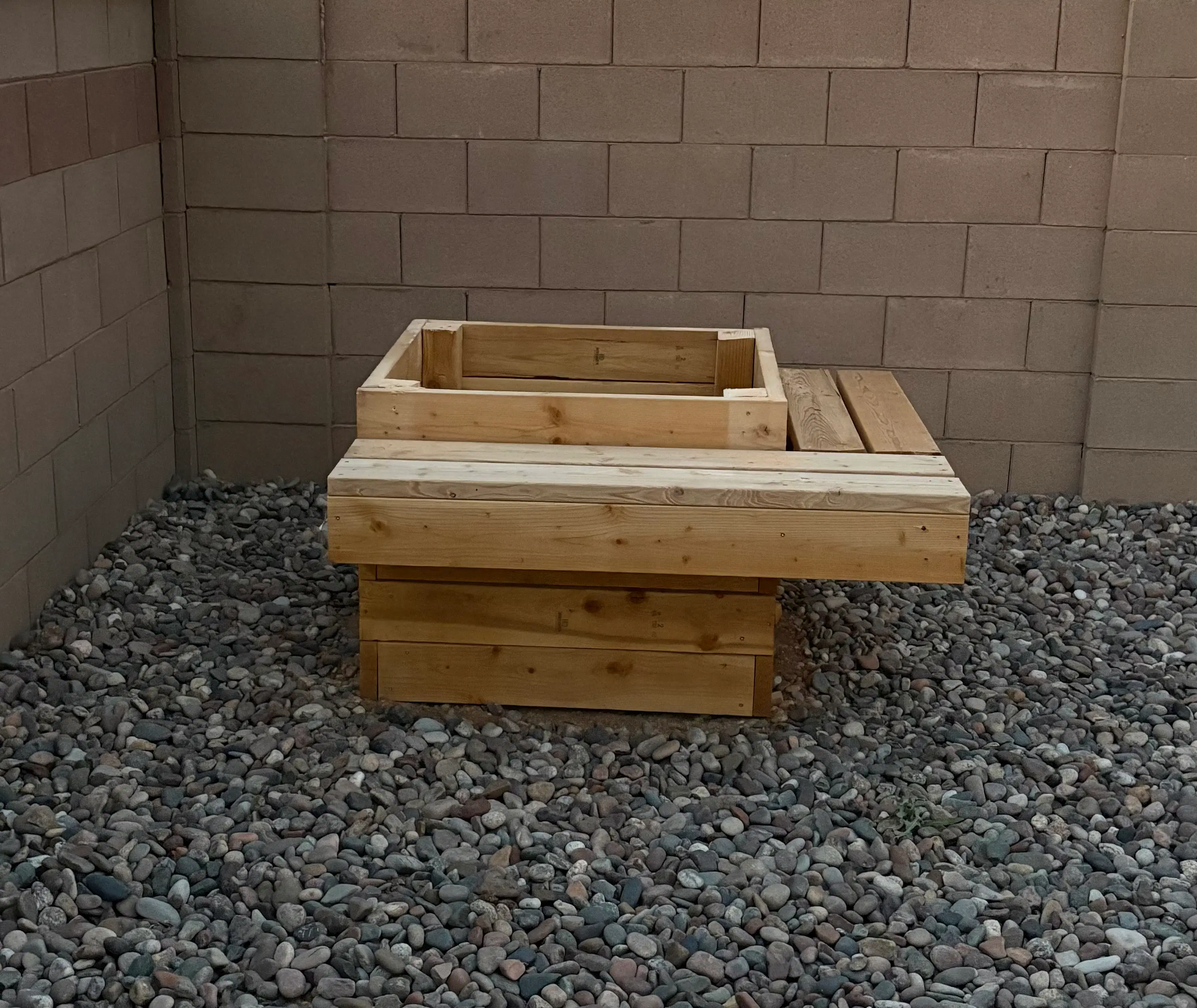 Custom-built rectangular wooden planter box with integrated bench