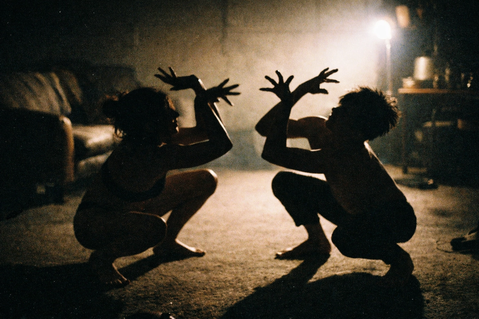Two silhouettes in a dark room mirroring a strange, non-rhythmic pose—Shadow Mirroring as a quiet little trust exercise.