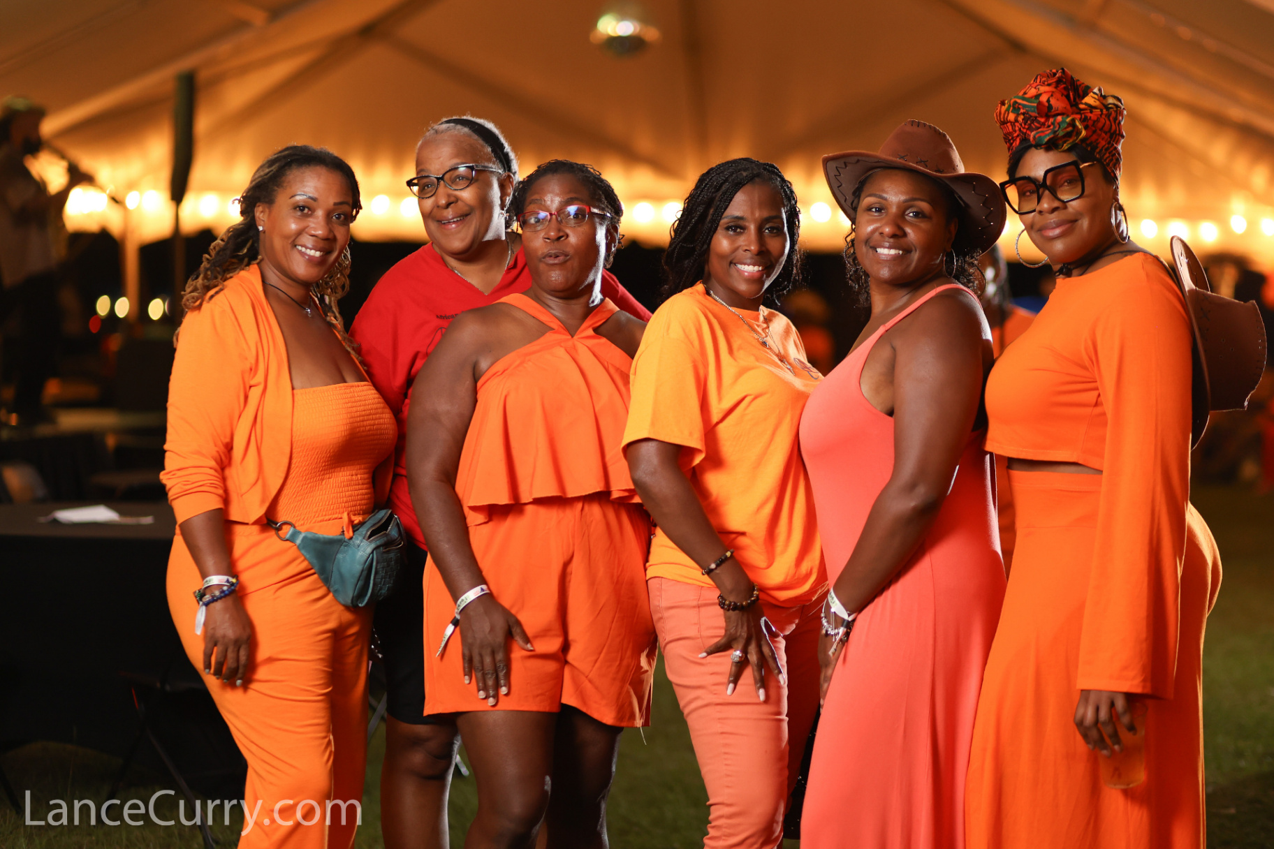 Six women in vibrant outfits enjoying the community vibe at Melanated Campout