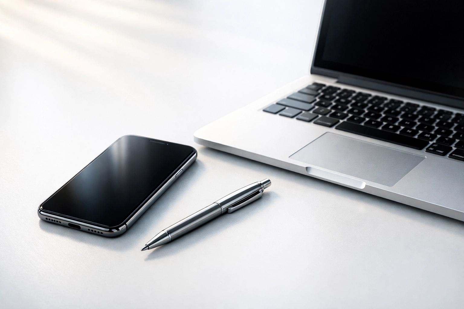 Modern office desk with a smartphone and laptop ready for efficient small business lead management.