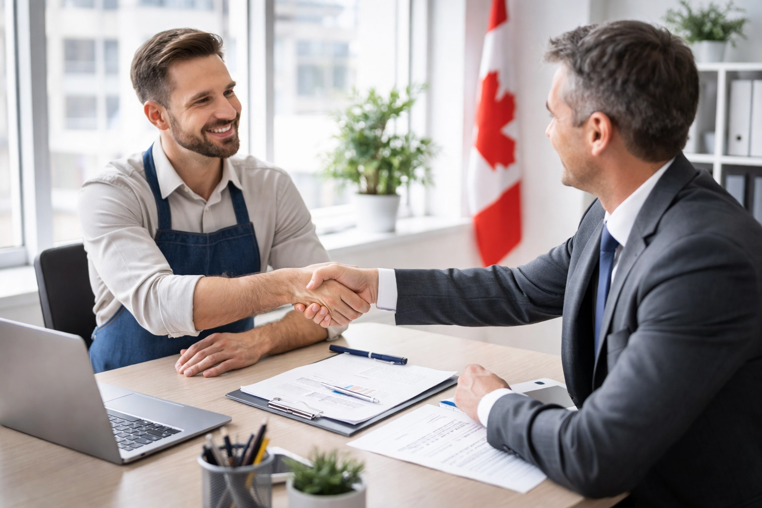 Small business owner shaking hands with bank representative during CSBFL loan approval meeting