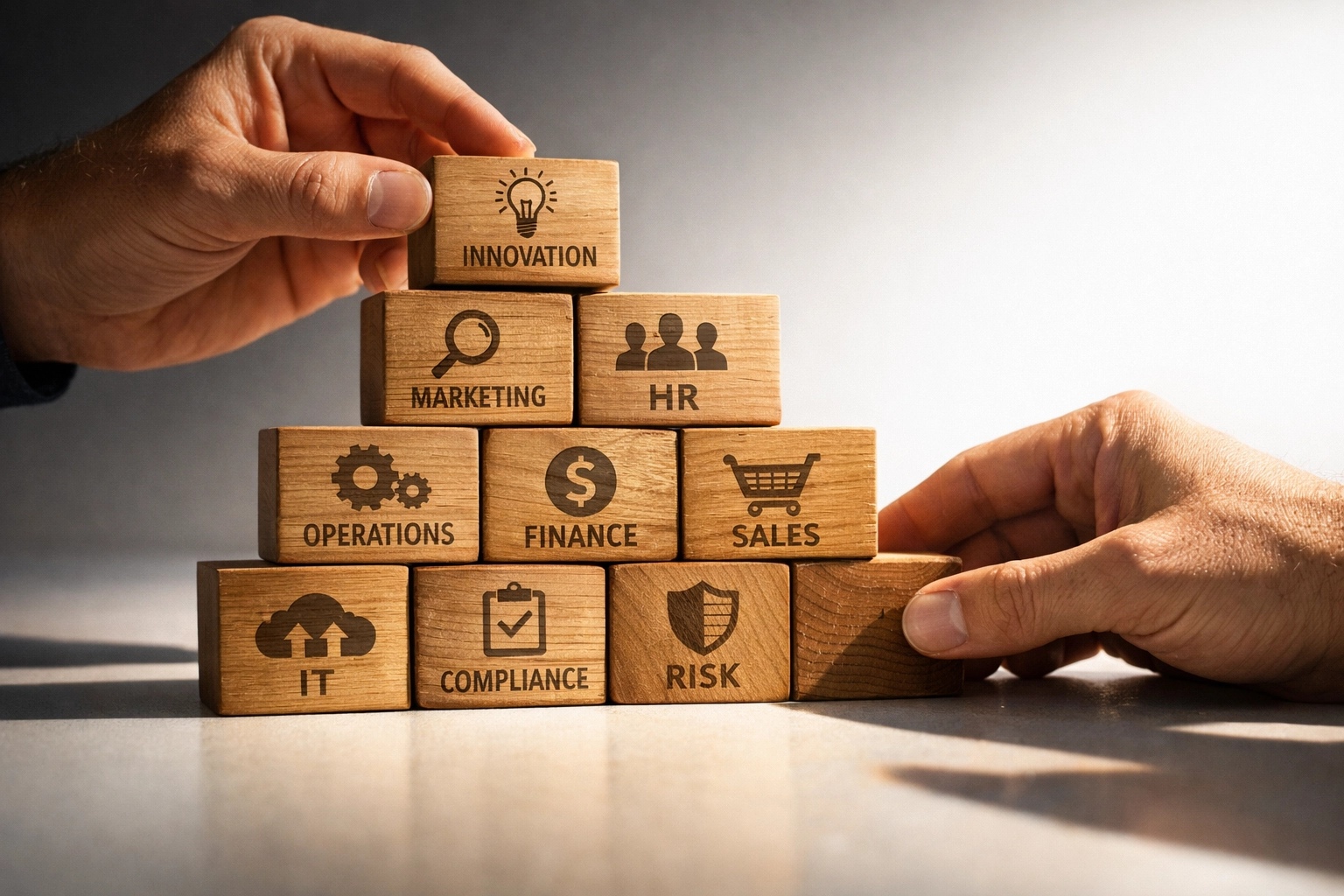 Hands stacking building blocks representing foundational startup back office systems