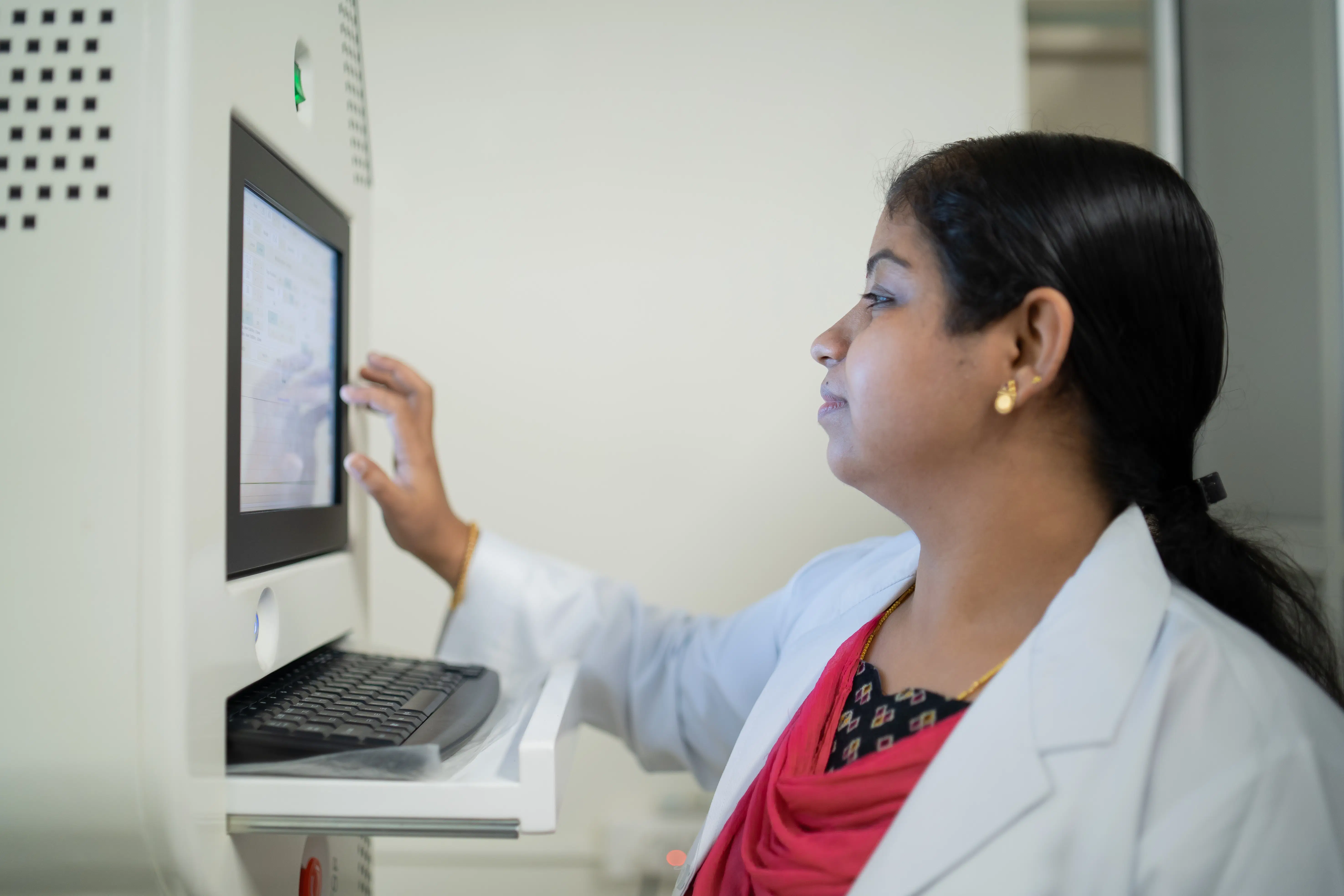 A Maana Health doctor operates an advanced diagnostic device, reviewing patient data on a touchscreen interface for non-invasive evaluation as part of our holistic treatment approach.