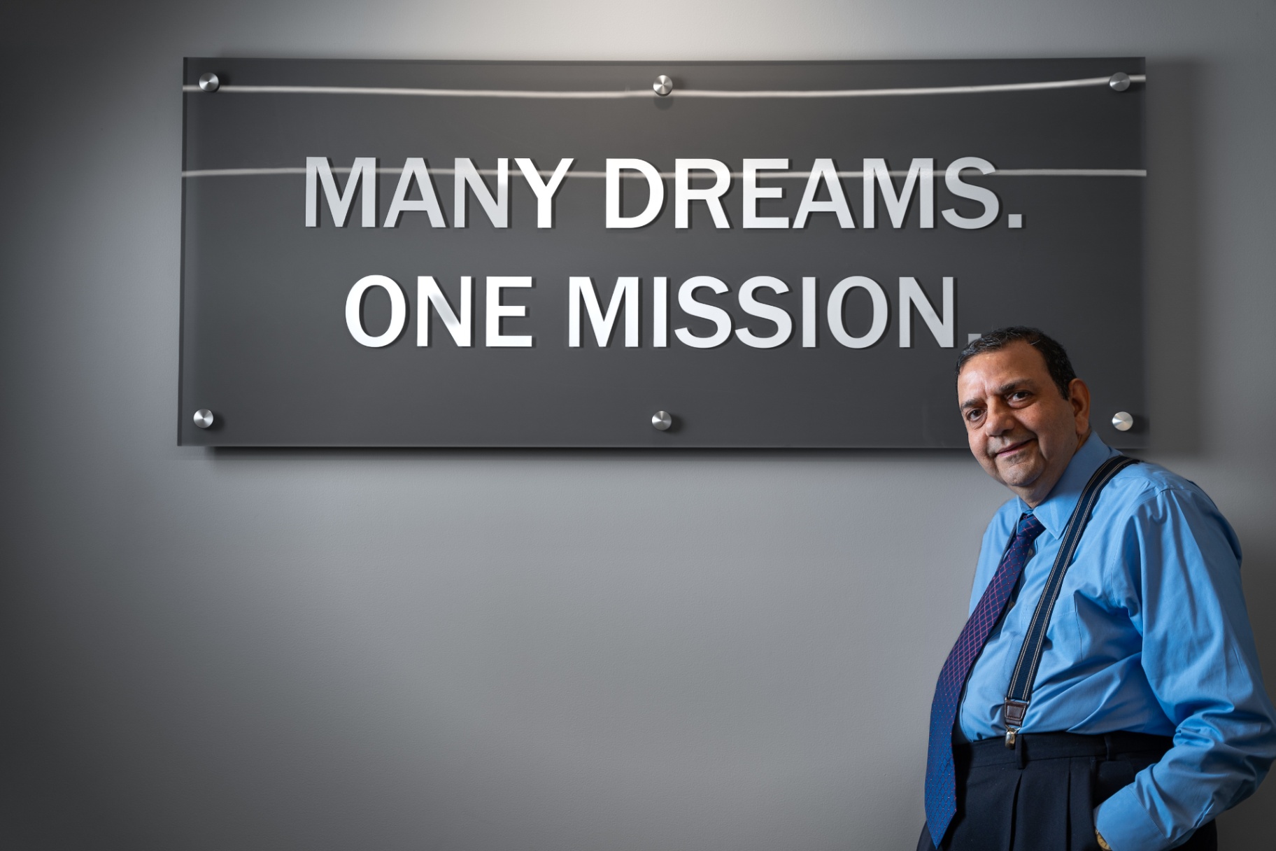 Professionally dressed man in front of corporate sign