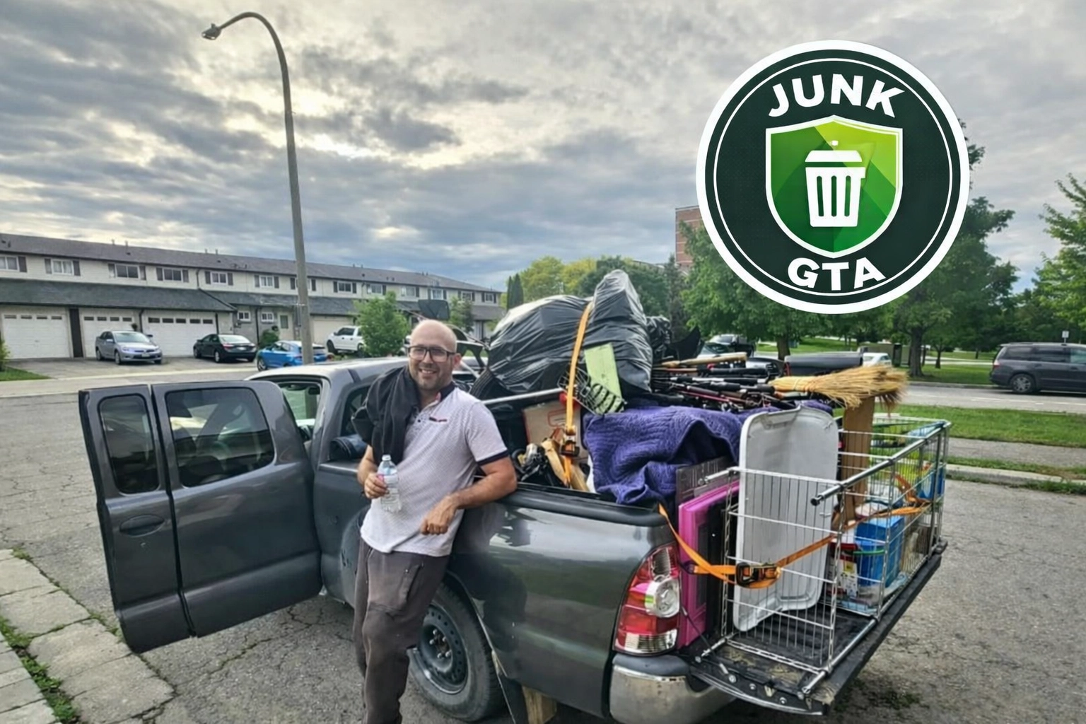 Junk GTA crew member stands beside a loaded truck prepared for responsible disposal