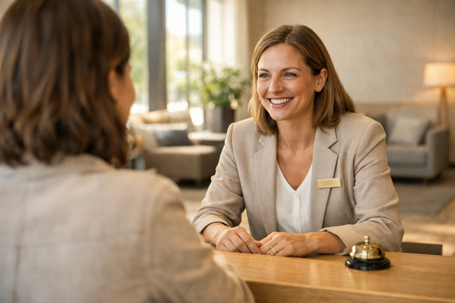 Hotel receptionist providing personalized service to a guest in a calm lobby after AI reduced interruptions.